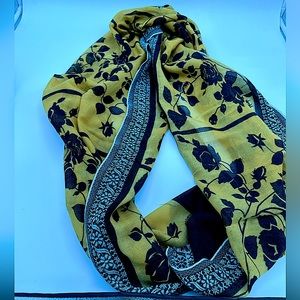 Black and mustard colored scarf, floral pattern and edges.